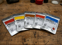 Laden Sie das Bild in den Galerie-Viewer, Five packages of &#39;Project&#39; metal clay on a wooden surface